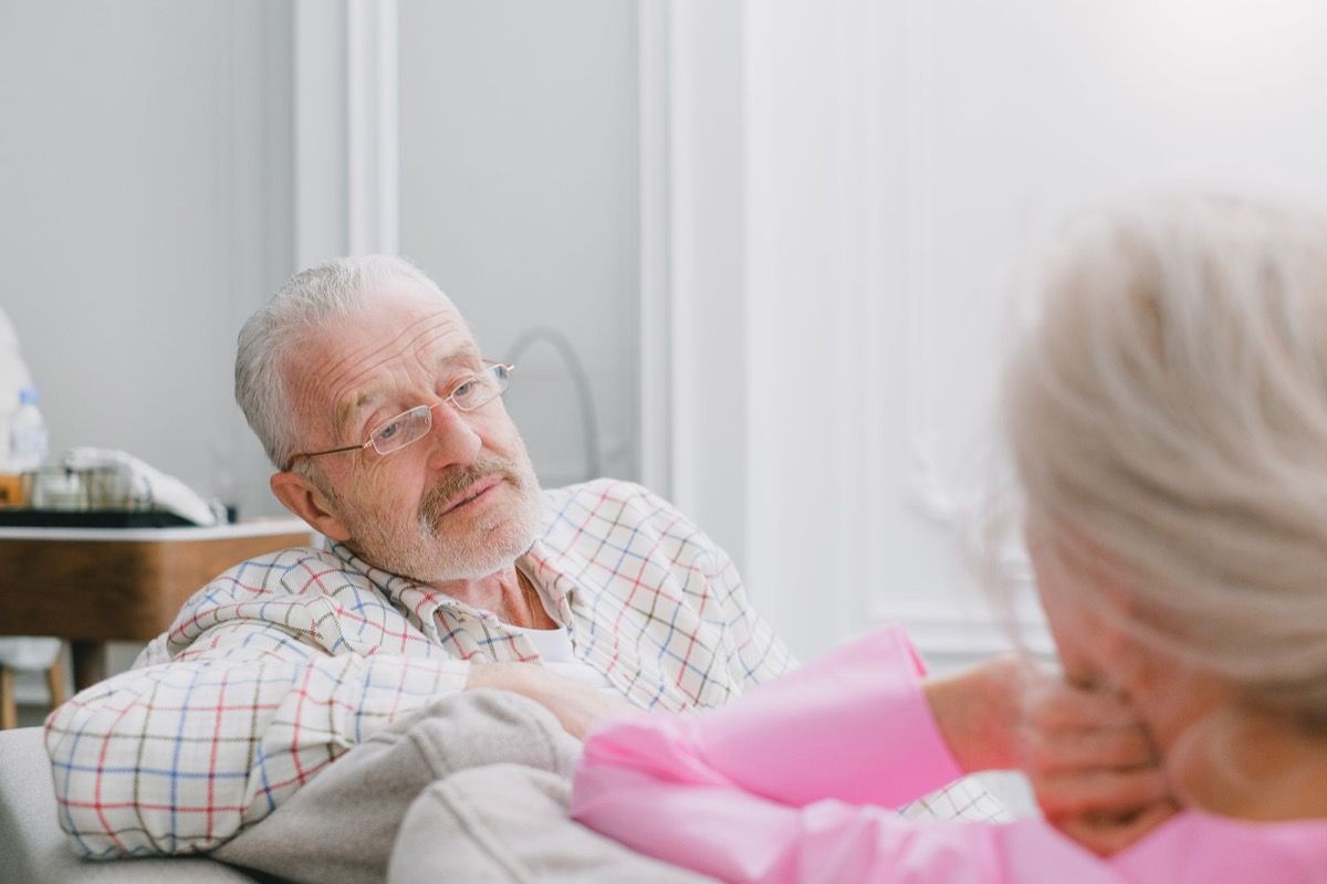 Two adults over 50 talking together at home, engaged in conversation