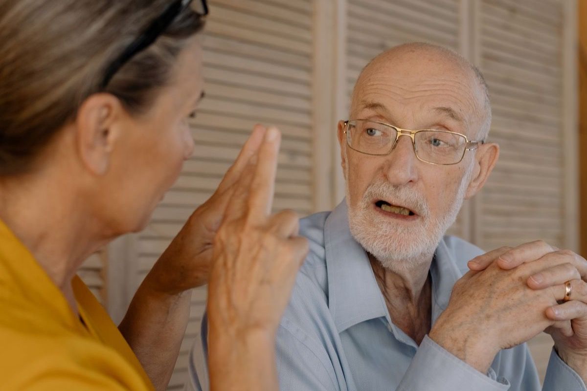 Two adults over 50 talking calmly together, showing comfortable emotional connection